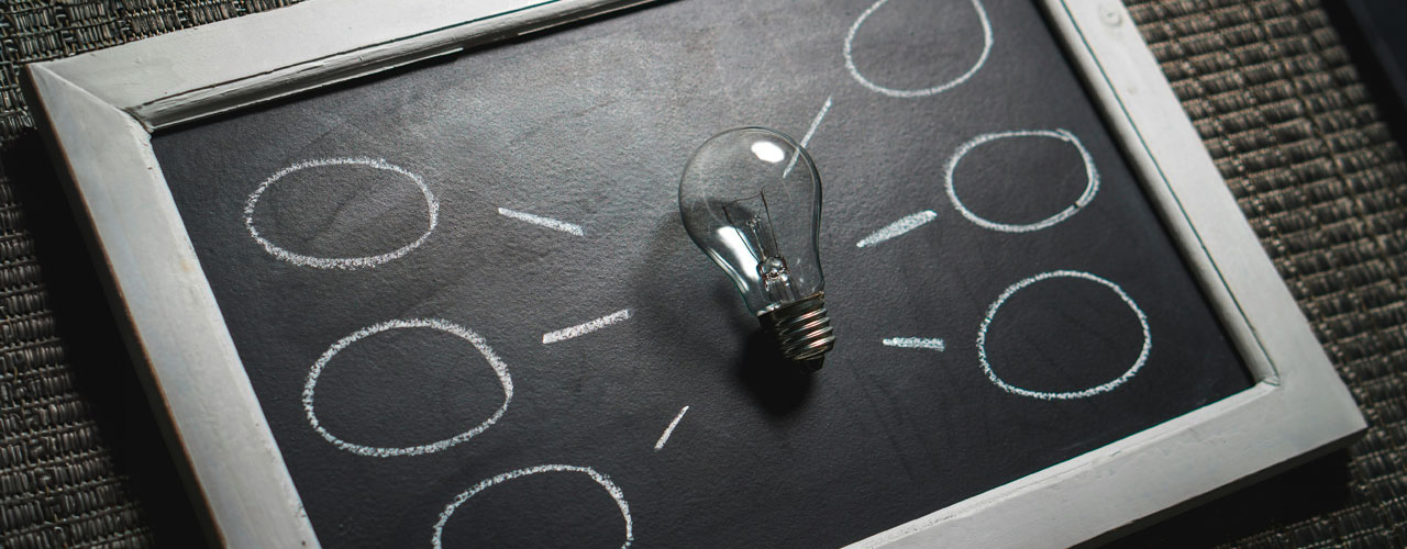 Black and white picture with a light bulb on a picture frame with a black background